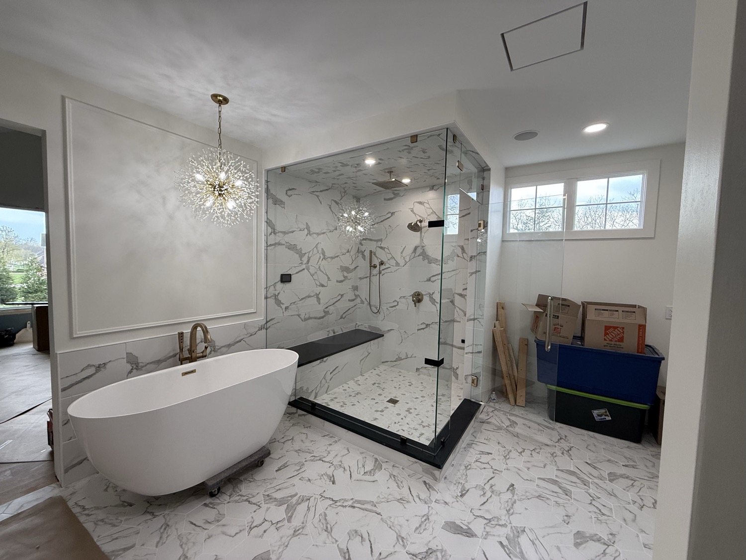 Finished marble bathroom with freestanding tub and glass shower