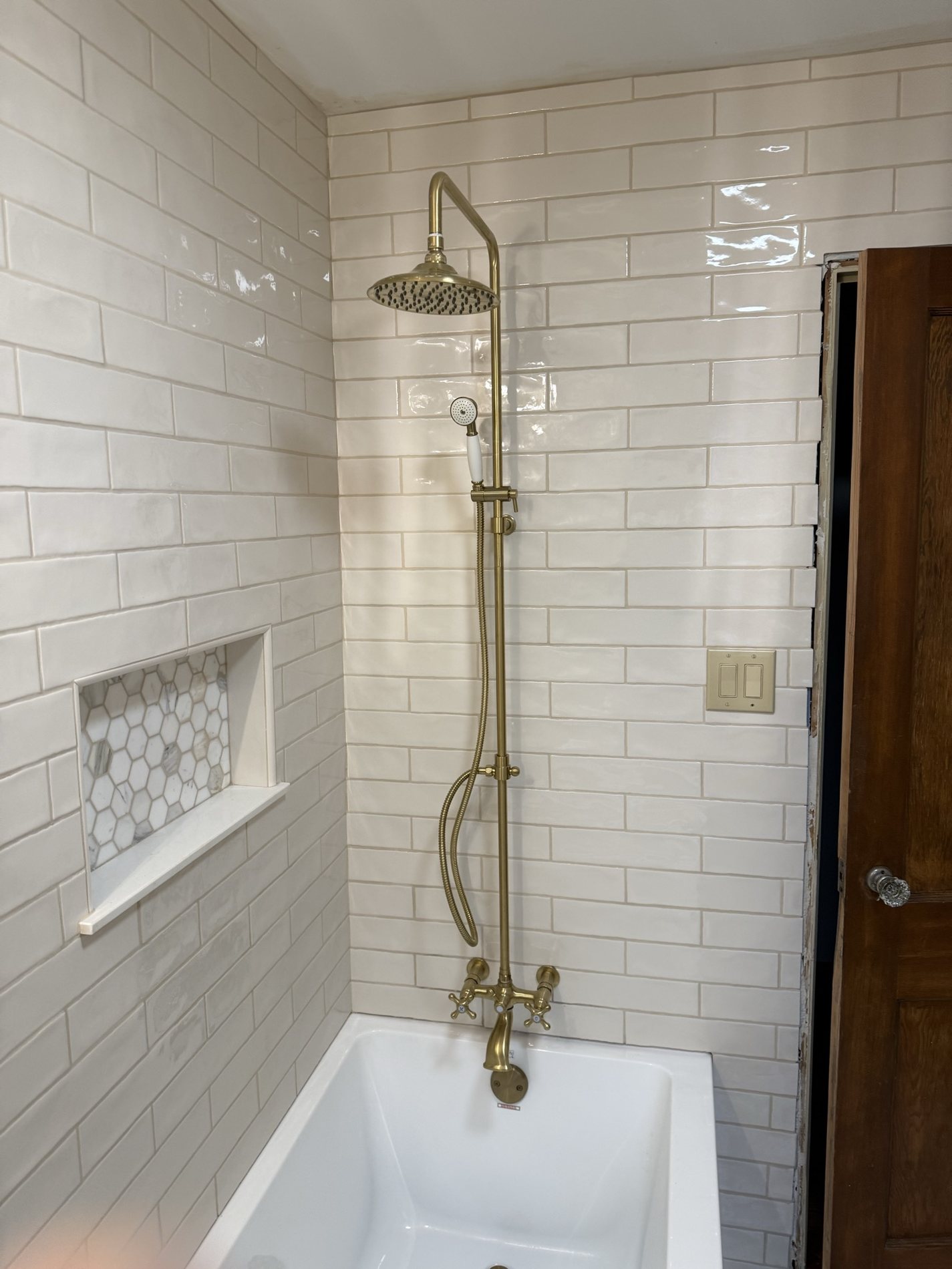 Subway tile shower with brass fixtures