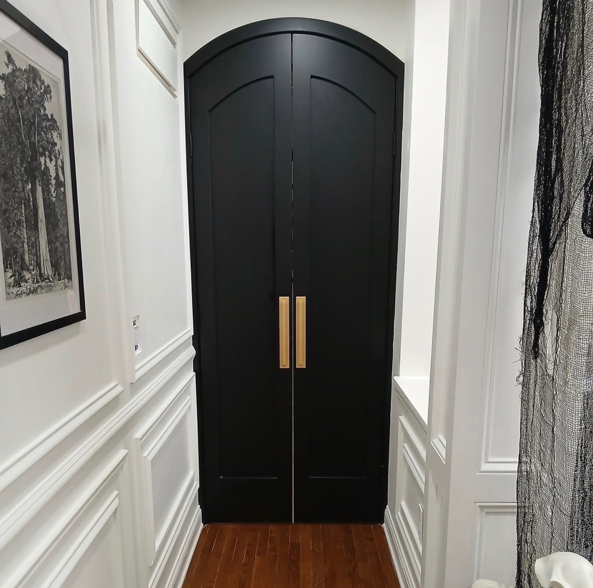 Custom black arched double doors with wainscoting