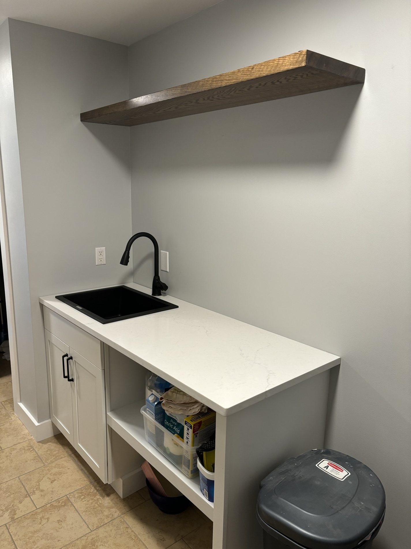 Laundry area with floating wood shelf and quartz counter
