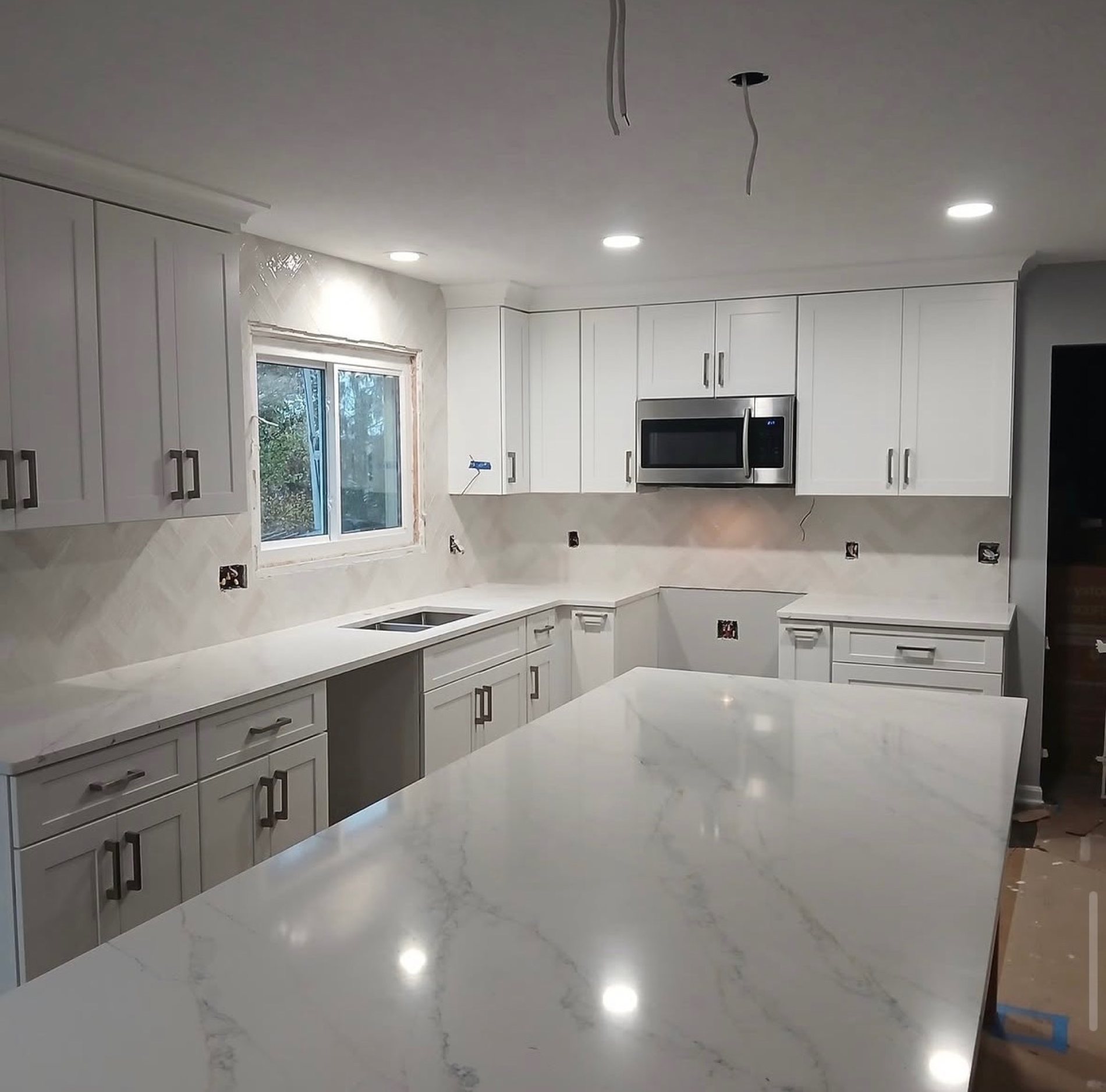 White shaker kitchen with marble waterfall island